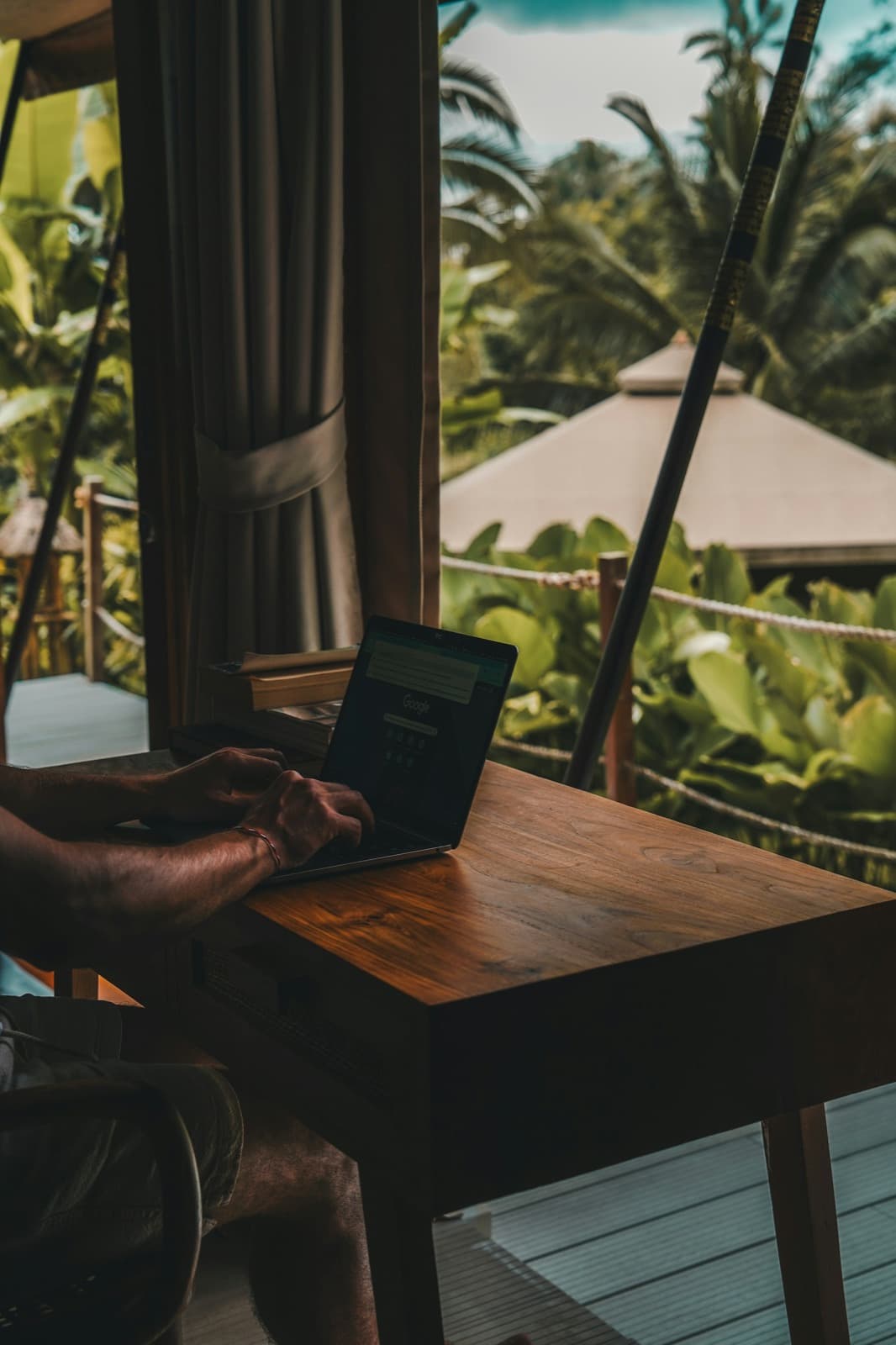 A laptop on a desk overlooking a garden