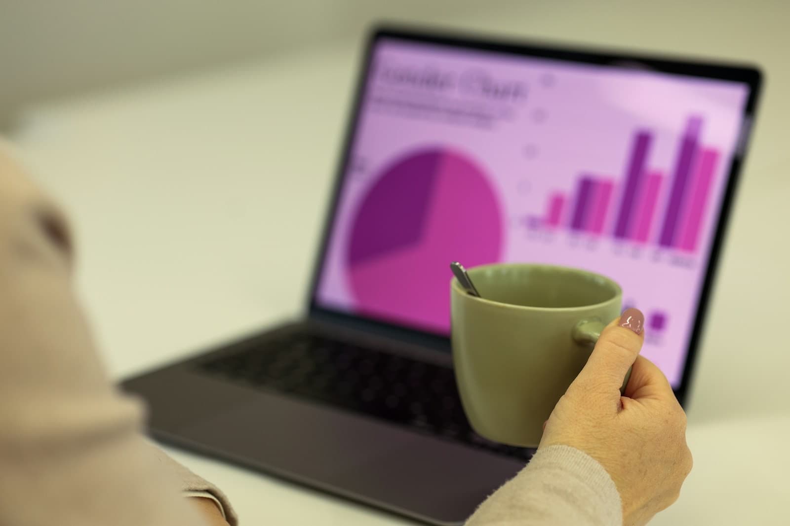 Progress charts on a laptop beside a cup of tea