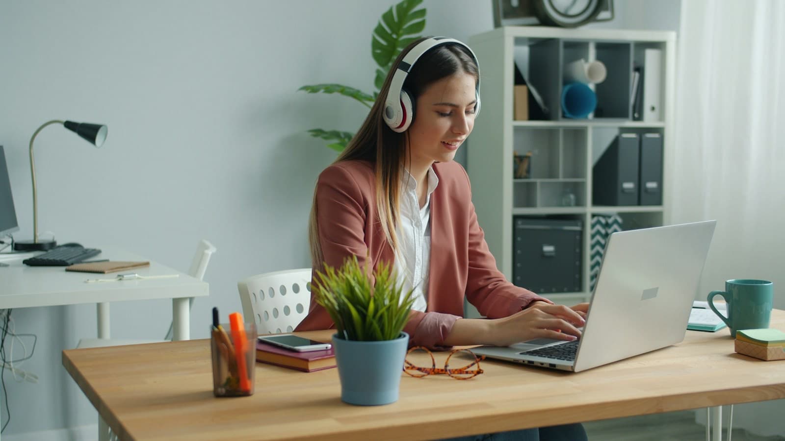 An assistant with headphones working at a home desk